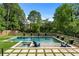 Beautiful pool with shallow entrance, spa, and lovely lounge chairs surrounded by greenery and stone pavers at 2373 Sagamore Hills Dr, Decatur, GA 30033