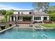 Backyard pool with shallow entrance and sunbathing chairs, surrounded by landscaped yard and covered patio at 2373 Sagamore Hills Dr, Decatur, GA 30033