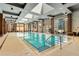 Well-lit indoor pool with lane markers, floor-to-ceiling windows, and skyline views at 40 12Th Ne St # 803, Atlanta, GA 30309