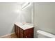 A vanity with a dark wood cabinet and a white sink with a mirror and overhead lighting at 5019 Lower Elm St, Atlanta, GA 30349