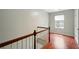 Hallway with wood floors, wood banister, and natural light from a window at 5019 Lower Elm St, Atlanta, GA 30349