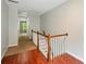 Upstairs hallway with hardwood floors and staircase with white and wood railing at 5019 Lower Elm St, Atlanta, GA 30349