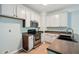 Well-lit kitchen with white cabinets, stainless steel appliances, and granite countertops at 5019 Lower Elm St, Atlanta, GA 30349