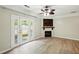 Sunlit living room with hardwood floors, fireplace, TV, and French doors leading to the backyard at 5019 Lower Elm St, Atlanta, GA 30349