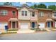 Townhomes with brick and vinyl siding, offering an attached garage, and landscaped surroundings at 5019 Lower Elm St, Atlanta, GA 30349