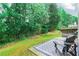 Lush backyard and patio featuring mature trees, vibrant grass, and outdoor seating at 75 Saltcreek Pt, Sugar Hill, GA 30518