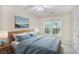 Cozy staged bedroom with a plush blue comforter, bedside tables and a window view at 75 Saltcreek Pt, Sugar Hill, GA 30518