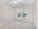 Unstaged bedroom featuring a large window overlooking lush greenery and neutral carpet at 75 Saltcreek Pt, Sugar Hill, GA 30518