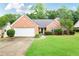 Charming single-story brick home with a well-manicured lawn and an attached two-car garage at 75 Saltcreek Pt, Sugar Hill, GA 30518