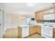 An efficient kitchen with stainless appliances, light wood cabinets, and hardwood floors at 75 Saltcreek Pt, Sugar Hill, GA 30518