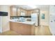 An efficient kitchen with stainless appliances, light wood cabinets, and hardwood floors at 75 Saltcreek Pt, Sugar Hill, GA 30518