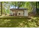 Spacious backyard featuring a covered carport, beautiful grass, and mature trees at 2889 Macon Sw Dr, Atlanta, GA 30354