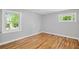 Well-lit bedroom with hardwood floors, neutral walls, and large windows showcasing green outdoor views at 2889 Macon Sw Dr, Atlanta, GA 30354