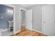The bedroom features neutral paint, hardwood floors, and an attached bathroom with blue walls and a vanity at 2889 Macon Sw Dr, Atlanta, GA 30354