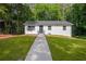 Charming, renovated one-story home with a white exterior and welcoming front lawn at 2889 Macon Sw Dr, Atlanta, GA 30354