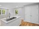 Bright kitchen showcasing stainless steel sink, white cabinets, light countertops and hardwood floors at 2889 Macon Sw Dr, Atlanta, GA 30354