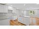 Open concept kitchen with a stainless steel sink, white cabinets, hardwood floors, and a view to the backyard at 2889 Macon Sw Dr, Atlanta, GA 30354