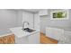 Modern kitchen featuring white cabinets, stone countertops, and a stylish island with seating at 2889 Macon Sw Dr, Atlanta, GA 30354