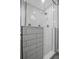 Modern tiled shower with glass door, black and white tiled floor, and sleek fixtures at 2889 Macon Sw Dr, Atlanta, GA 30354