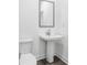 Bright half-bathroom features pedestal sink and mirror, along with a white toilet at 3269 Shirecrest Ln, Dacula, GA 30019