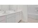 Bathroom featuring double sinks, white cabinets, a large mirror, and a view to the shower and toilet room at 3269 Shirecrest Ln, Dacula, GA 30019