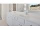 Bathroom featuring double sinks, white cabinets, a large mirror, and a view to the shower and toilet room at 3269 Shirecrest Ln, Dacula, GA 30019