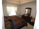 Cozy bedroom with a colorful quilt, natural light, and a matching dark wood dresser at 6179 Swabia Ln, Stone Mountain, GA 30087