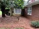 View of the backyard of the brick house with mature tree and bird bath at 1818 Brandy Woods Se Dr, Conyers, GA 30013