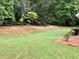 Large backyard with a grassy lawn and trees at 1818 Brandy Woods Se Dr, Conyers, GA 30013