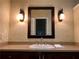Bathroom vanity with dark wood cabinets, light colored countertops and decorative mirror at 1818 Brandy Woods Se Dr, Conyers, GA 30013