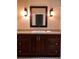 Bathroom vanity with dark wood cabinets, light colored countertops and decorative mirror at 1818 Brandy Woods Se Dr, Conyers, GA 30013