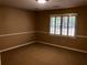 Bedroom with carpet and trim, light coming from window, tan walls at 1818 Brandy Woods Se Dr, Conyers, GA 30013