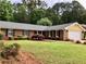 A beautifully landscaped brick home with a well-manicured lawn and mature trees at 1818 Brandy Woods Se Dr, Conyers, GA 30013