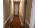 Hallway with wood floors and tan walls with white trim, leading to a white door at 1818 Brandy Woods Se Dr, Conyers, GA 30013
