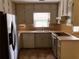 Kitchen featuring tile flooring, wood cabinets, stainless steel refrigerator, and window at 1818 Brandy Woods Se Dr, Conyers, GA 30013