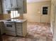 Kitchen with tile flooring, wood cabinets, white appliances, pantry, and window at 1818 Brandy Woods Se Dr, Conyers, GA 30013