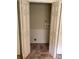 Small laundry room area with wainscotting and tile flooring behind bifold doors at 1818 Brandy Woods Se Dr, Conyers, GA 30013