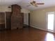 Living room featuring hardwood floors, brick fireplace, ceiling fan, and a glass door at 1818 Brandy Woods Se Dr, Conyers, GA 30013