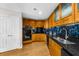 Stylish kitchen featuring wood cabinetry, black appliances, and stone countertops at 2881 Peachtree Ne Rd # 1102, Atlanta, GA 30305