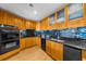 Stylish kitchen featuring wood cabinetry, black appliances, and stone countertops at 2881 Peachtree Ne Rd # 1102, Atlanta, GA 30305