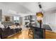 Open-concept living room with fireplace, island bar, hardwood floors, and chandelier at 2881 Peachtree Ne Rd # 1102, Atlanta, GA 30305