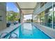 An outdoor lap pool with comfortable deck furniture and views of the sky, partially enclosed by glass walls at 2881 Peachtree Ne Rd # 1102, Atlanta, GA 30305