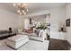 Bright living room with a light colored sofa, ottoman, area rug and an open view into the modern kitchen at 307 Cedar Dust Dr, Decatur, GA 30030