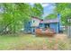 Blue two-story home with a deck, partially fenced yard, and mature trees at 3178 Booths Ct, Dacula, GA 30019