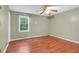 Bedroom featuring a window offering natural light, complimented by hardwood floors and a ceiling fan at 3178 Booths Ct, Dacula, GA 30019