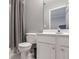 Bathroom featuring a white toilet and vanity, framed mirror, and shower with a gray curtain at 4765 Silver Leaf Dr, Cumming, GA 30040