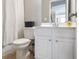 Cozy bathroom with white cabinets, a standard toilet, and a shower with a textured curtain at 4765 Silver Leaf Dr, Cumming, GA 30040