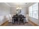 Formal dining room features a modern chandelier, wainscoting, and a large window for ample natural light at 4765 Silver Leaf Dr, Cumming, GA 30040