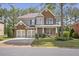 Charming two-story brick home with a well-manicured lawn, a two-car garage, and a welcoming front porch at 4765 Silver Leaf Dr, Cumming, GA 30040