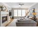 Inviting living room with a fireplace, built-in shelving, hardwood floors, and large windows at 4765 Silver Leaf Dr, Cumming, GA 30040